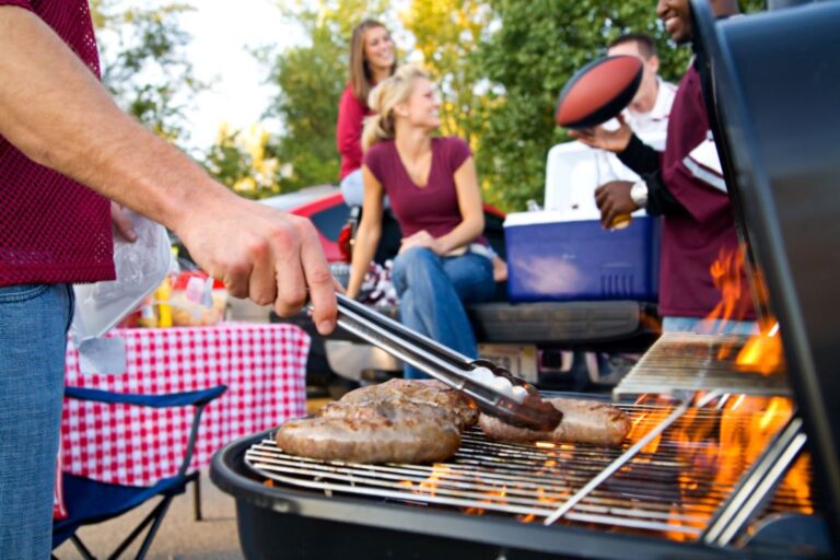 grill with meat in front of people enjoying a barbecue